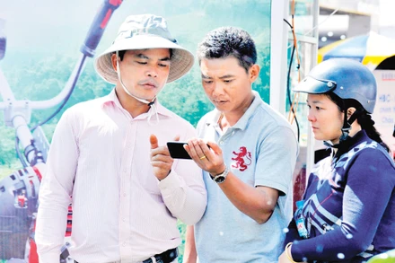 Người nông dân tìm hiểu các ứng dụng của điện thoại thông minh để phục vụ cho sản xuất. Ảnh: Hải Nam