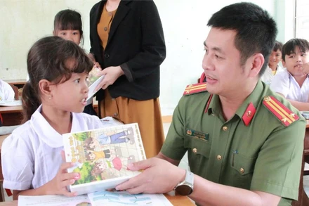 Cán bộ Công an tỉnh Đắk Lắk trao tặng sách vở cho học sinh vùng lũ tại xã Phú Mỡ sau khi các em trở lại trường học.