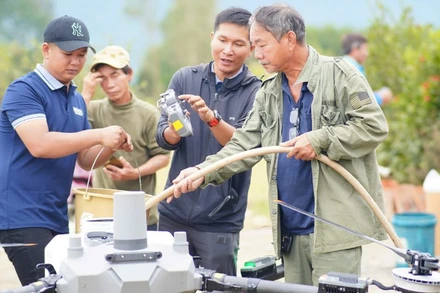 Các thành viên nhóm Drone Phản ứng nhanh thuộc Ứng cứu 3 miền bơm nước vào bình để pha hoá chất khử khuẩn.