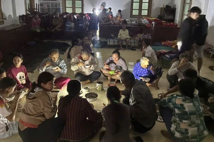 Người dân xã Xuân Cảnh quây quần dùng bữa tối tại Doanh trại Đồn Biên phòng Xuân Hòa trong thời gian trú tránh bão số 13.