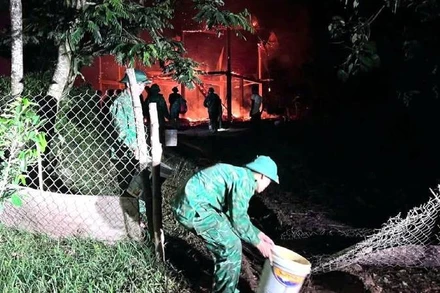 Cán bộ, chiến sĩ Đồn Biên phòng Ba Tầng nỗ lực dập lửa cháy nhà dân.