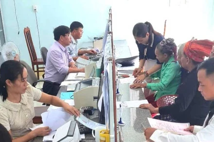Cán bộ xã Kim Ngân, tỉnh Quảng Trị hướng dẫn, hỗ trợ người dân là đồng bào dân tộc Bru-Vân Kiều làm giấy tờ, hồ sơ hành chính.