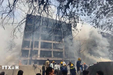 Lực lượng chức năng làm nhiệm vụ tại hiện trường máy bay Boeing 787-8 Dreamliner của Hãng Air India rơi trúng tòa nhà tại thành phố Ahmedabad, bang Gujarat (Ấn Độ) ngày 12/6/2025. (Ảnh: THX/TTXVN)