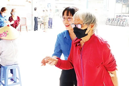 Nhân viên Phòng Công tác xã hội chăm lo người bệnh cao tuổi đi lại khó khăn.