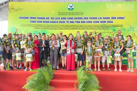 Lãnh đạo tỉnh Vĩnh Long trao quà cho khách quốc tế đầu tiên đến Vĩnh Long. 