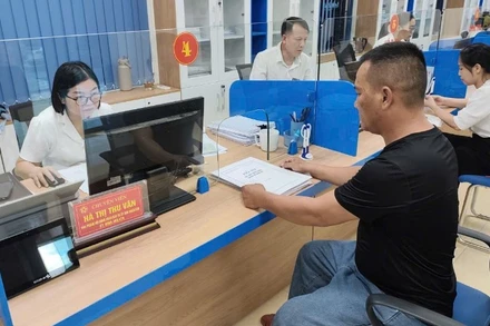 Cán bộ trung tâm phục vụ hành chính công hướng dẫn người dân thủ tục hành chính sau khi sắp xếp đơn vị hành chính theo mô hình chính quyền địa phương 2 cấp. (Ảnh: MINH PHƯƠNG)