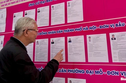 Người dân phường Đại Mỗ, thành phố Hà Nội tìm hiểu thông tin về các ứng cử viên. (Ảnh: PH.NGÂN) 