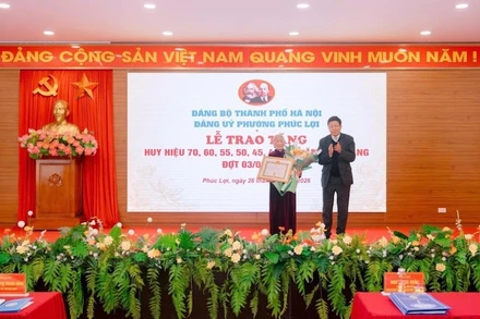 Lãnh đạo Ủy ban nhân dân thành phố Hà Nội trao Huy hiệu 70 năm tuổi Đảng cho đảng viên lão thành.