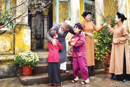 Nụ cười sum vầy của gia đình miền bắc với cành đào xuân là biểu tượng thiêng liêng của sự gắn kết và ấm áp trong ngày Tết cổ truyền.