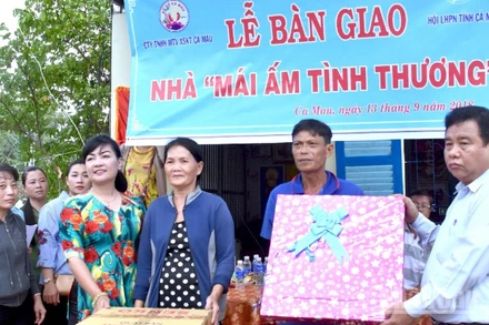 Đại diện Công ty trách nhiệm hữu hạn một thành viên Xổ số kiến thiết Cà Mau trao quà an sinh xã hội cho người dân vùng nông thôn.