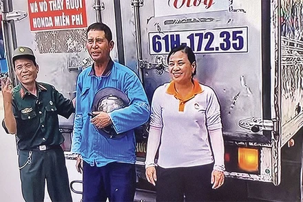 Ông Nguyễn Đức Quân va bà Phạm Thị Vân (bên phải) và chiếc xe “cứu nạn” của mình.