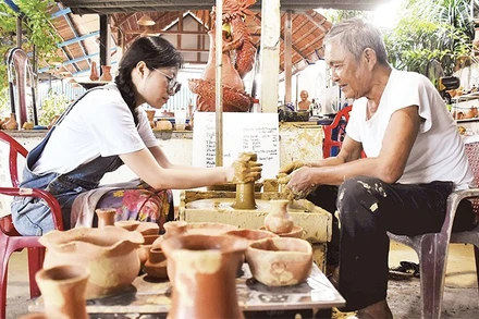 Du khách trải nghiệm làm đồ gốm khi tới thăm làng Thanh Hà.