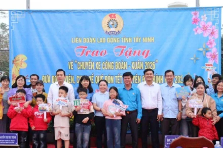 Lãnh đạo Mặt trận Tổ quốc Việt Nam và Liên đoàn Lao động tỉnh Tây Ninh trao vé xe nghĩa tình cho công nhân cùng người thân có mặt từ sớm, mang theo hành lý và niềm vui rạng rỡ trước giờ lên xe