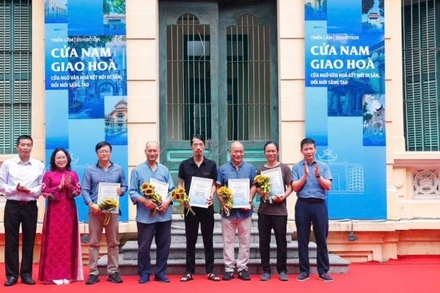 Bí thư Đảng ủy phường Cửa Nam Phạm Tuấn Long tặng hoa các tác giả có tác phẩm trưng bày tại triển lãm “Cửa Nam giao hòa - Cửa ngõ văn hóa, kết nối di sản, đổi mới sáng tạo”.