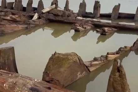 Một phần thân tàu cổ phát lộ sau khi thuỷ triều xuống. (Ảnh: Người dân cung cấp)