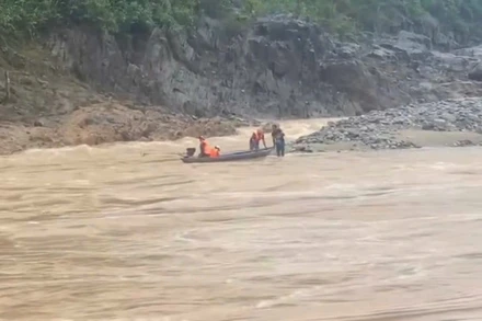 Lực lượng chức năng sử dụng xuồng máy tiếp cận khu vực hai người dân mắc kẹt, đưa họ về bờ. (Ảnh: địa phương cung cấp)