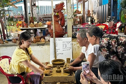Du khách trải nghiệm làm gốm tại Làng gốm Thanh Hà. (Ảnh: ANH ĐÀO)