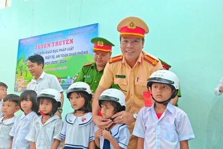 Công an xã A Vương phối hợp với Đội Cảnh sát giao thông đường bộ Số 3, Phòng PC08, Công an thành phố Đà Nẵng tặng mũ bảo hiểm cho học sinh.