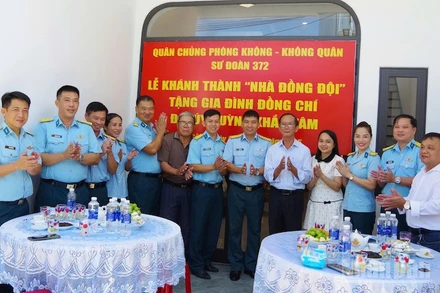 Các đại biểu dự buổi khánh thành và bàn giao “Nhà đồng đội” chụp ảnh lưu niệm với gia đình Đại úy Huỳnh Khắc Tâm. (Ảnh: VĂN TÂM)