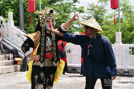 Du khách nước ngoài tương tác trực tiếp với diễn viên biểu diễn nghệ thuật biến mặt trên trường thành Mục Điền Dục.