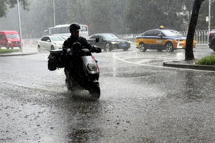 Một người đi xe đạp điện trong mưa ở quận Tây Thành, thành phố Bắc Kinh, Trung Quốc ngày 4/8. (Ảnh: Tân Hoa xã)