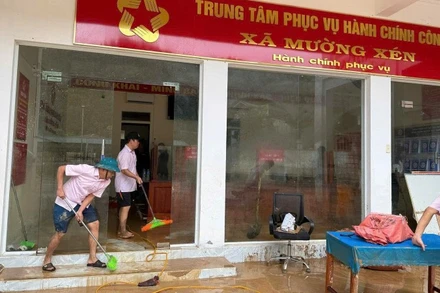 Cán bộ Phòng giao dịch Ngân hàng Chính sách xã hội Kỳ Sơn đồng hành cùng nhân dân xã Mường Xén khắc phục hậu quả lũ lụt.