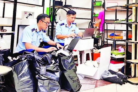 Lực lượng quản lý thị trường kiểm tra hàng hóa có dấu hiệu giả mạo tại điểm mua sắm Saigon Square (Quận 1) cuối tháng 5 vừa qua. (Ảnh CTV)