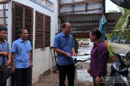 Bí thư Tỉnh ủy Cà Mau Nguyễn Hồ Hải (cầm phong bì) trao hỗ trợ cho hộ dân ấp Nhà Lầu 2 có nhà bị tốc mái.