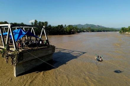 Một bức ảnh chụp từ trên cao vào ngày 1/12 cho thấy người dân băng qua sông bằng dây thừng sau khi một cây cầu bị lũ phá hủy ở Bireuen Regency, tỉnh Aceh, Indonesia. (Ảnh: Tân Hoa xã)