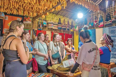 Du khách nước ngoài thích thú với những sản phẩm vải lanh của Lùng Tám. 