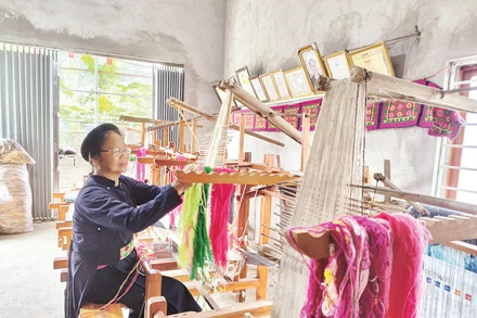Nghệ nhân Nông Thị Thược thực hành kỹ thuật dệt thổ cẩm. Ảnh: Văn Học 
