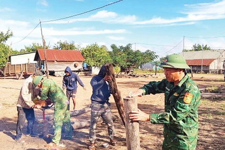 Cán bộ, chiến sĩ Đồn Biên phòng Ia Mơ giúp đỡ gia đình anh Rơ Mah Choan. Ảnh: ĐVCC