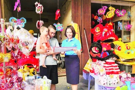 Cán bộ BHXH cơ sở Phúc Yên tuyên truyền, vận động người dân tham gia bảo hiểm y tế.