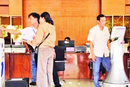 Cán bộ hướng dẫn người dân thao tác sử dụng các thủ tục hành chính tại phường Hội Phú, tỉnh Gia Lai. (Ảnh BÁ BÍNH)