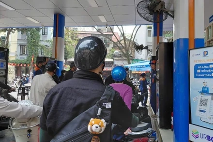 Người dân xếp hàng mua xăng tại cửa hàng trên phố Trần Hưng Đạo (Hà Nội). 