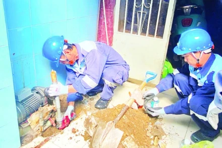 Công nhân Công ty cổ phần cấp nước Gia Định trám, lấp một giếng khoan tại phường Phú Nhuận nhằm hạn chế những tác động tiêu cực do hiện tượng mạch nước ngầm sụt giảm. (Ảnh QUÝ HIỀN)