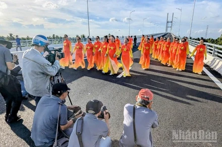 Người dân chụp ảnh lưu niệm trên cầu Rạch Miễu 2 trước ngày khánh thành, đưa vào sử dụng. (Ảnh: TRUNG HIẾU)