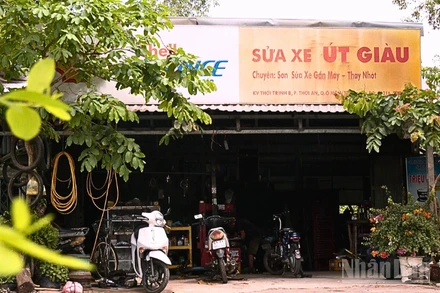 Tiệm sửa xe của ông Giàu nằm lọt thỏm giữa những tán cây ven đường.