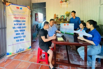 Đoàn viên, thanh niên tình nguyện hướng dẫn người dân nộp hồ sơ và trao giấy xác nhận mức độ khuyết tật tại nhà ở phường Cao Lãnh (tỉnh Đồng Tháp).