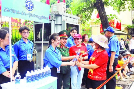 Đoàn viên thanh niên phường Hoàn Kiếm nhiệt tình giúp đỡ mọi người đến xem luyện tập diễu binh, diễu hành.