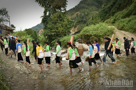 Đoàn rước dâu đi qua suối. (Ảnh: Vũ Linh) 