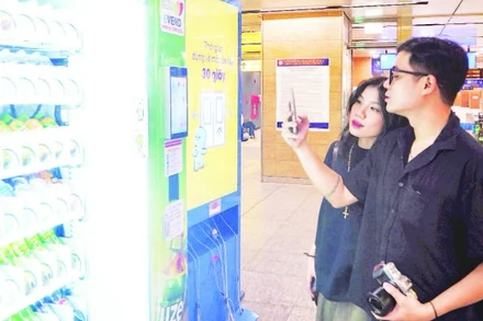 Hành khách mua đồ uống tại máy bán hàng tự động ở nhà ga ngầm của tuyến Metro Bến Thành-Suối Tiên. (Ảnh THẾ ANH)