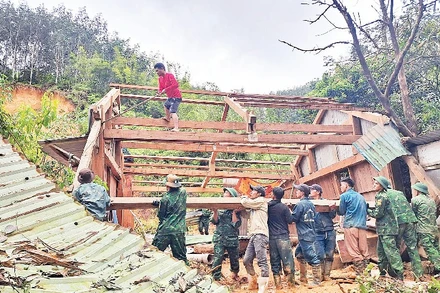 Đồn Biên phòng Anông cùng cán bộ, chiến sĩ xã Avương giúp người dân thôn Atếêp khắc phục hậu quả mưa lũ.