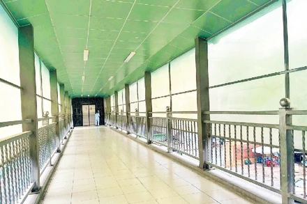 Dù được đầu tư hiện đại với hệ thống thang máy, cầu bộ hành tại Bệnh viện Ung Bướu cơ sở 1 (đường Nơ Trang Long) vẫn thưa thớt người sử dụng do thang máy nằm “biệt lập” trong khuôn viên bệnh viện. (Ảnh HƯƠNG MỸ)