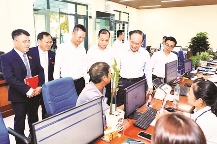 Lãnh đạo thành phố Hà Nội trao đổi với người dân đến làm thủ tục hành chính tại điểm Phục vụ hành chính công xã Phú Xuyên. (Ảnh LÊ HẢI)