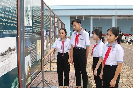 Học sinh xã Trung Thành, tỉnh Vĩnh Long xem triển lãm ảnh với chủ đề kỷ niệm 85 năm Ngày Khởi nghĩa Nam Kỳ.