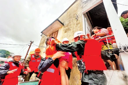 Cán bộ, chiến sĩ Nhà máy Z753 cứu giúp người dân Khánh Hòa ra khỏi vùng ngập sâu.