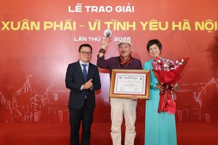 Đồng chí Lê Quốc Minh, Ủy viên Trung ương Đảng, Tổng Biên tập Báo Nhân Dân, Phó Trưởng ban Tuyên giáo và Dân vận Trung ương, Chủ tịch Hội Nhà báo Việt Nam cùng lãnh đạo Thông tấn xã Việt Nam trao Giải thưởng Lớn - Vì tình yêu Hà Nội được trao cho nhạc sĩ Trần Tiến.