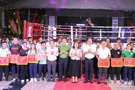 Các huấn luyện viên, vận động viên nhận cờ lưu niệm từ đơn vị tổ chức. 