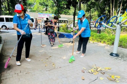 Người dân tham gia dọn dẹp vườn hoa Trần Quang Diệu sau một thời gian bị xuống cấp. 